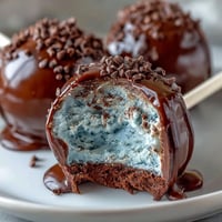 Bouchées de gâteau bleu œuf de robin enrobées de chocolat bleu et parsemées pour une touche festive de Pâques. Parfaites pour les célébrations printanières et les tables de desserts.